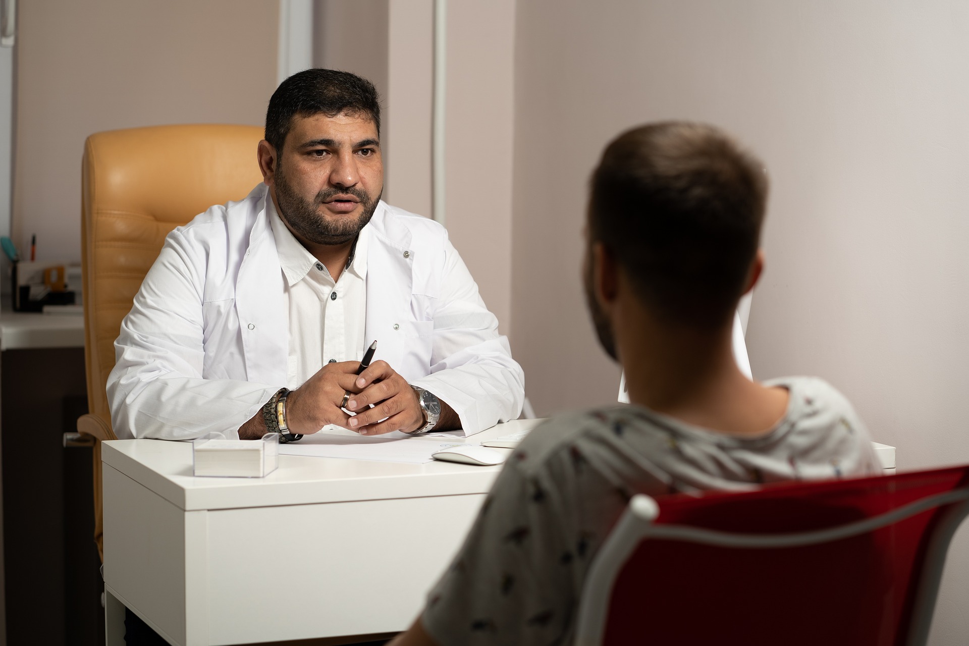 A doctor sitting at a desk in front of a man