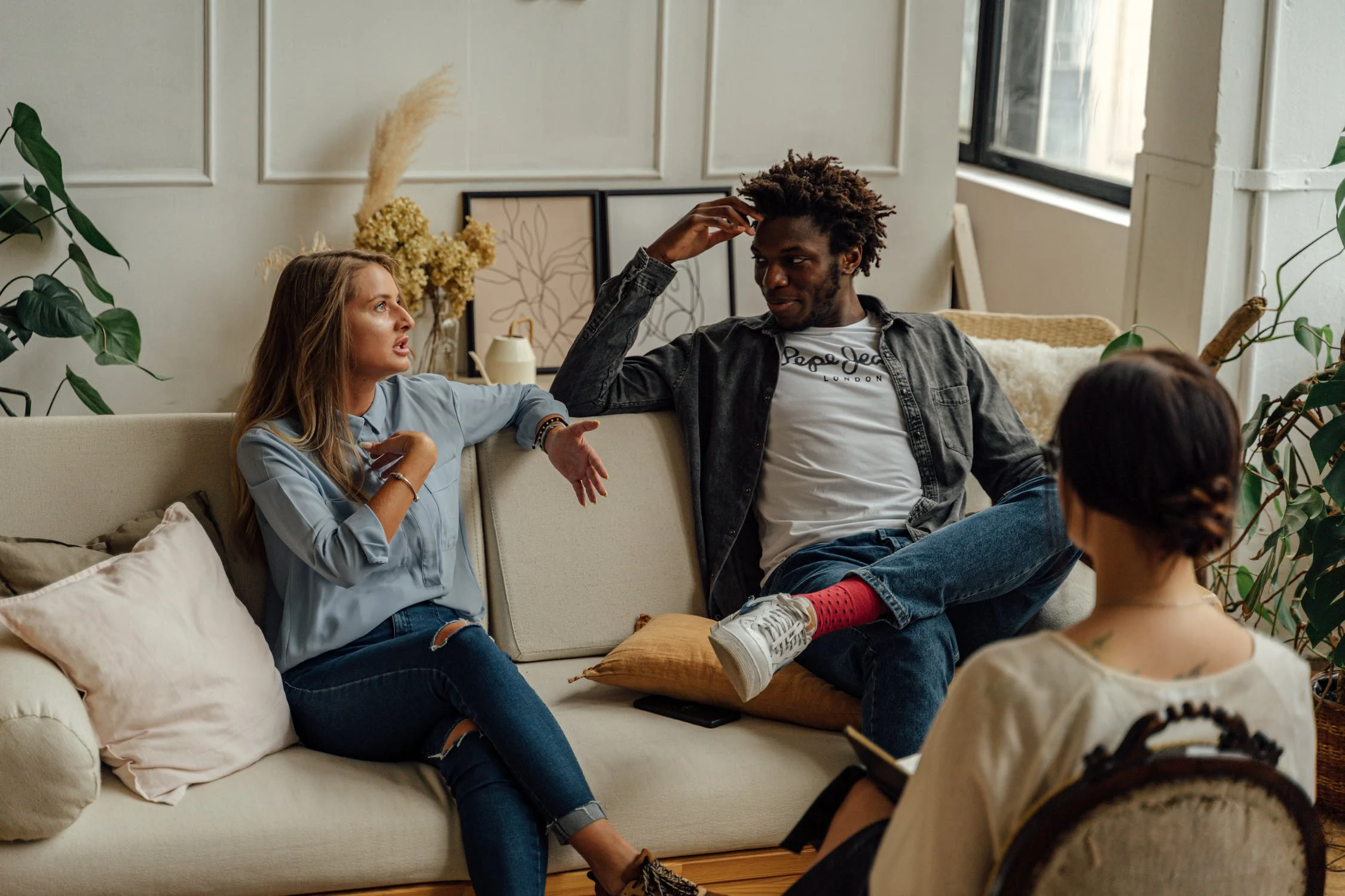 two people sitting on a couch in a living room