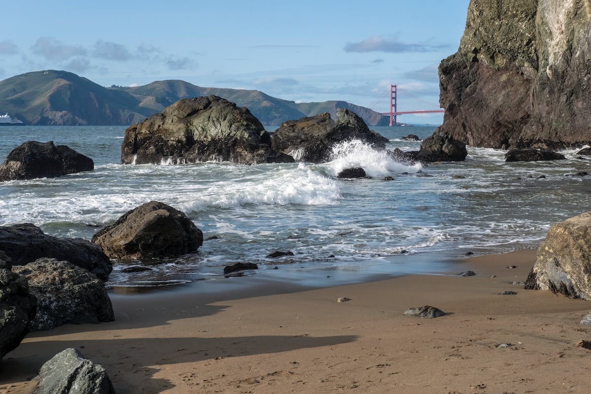 a beach with rocks and water near the shore