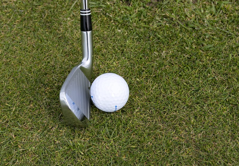 a golf club and a ball on the grass