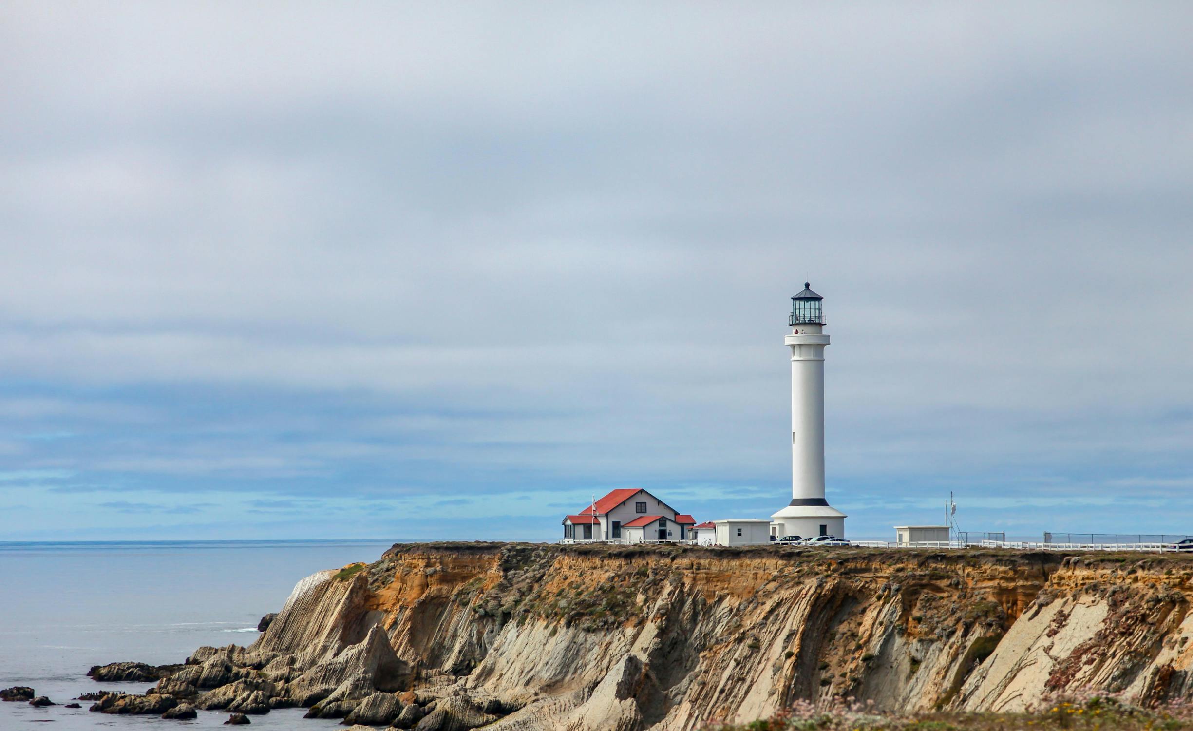 a lighthouse on top of a cliff near the ocean